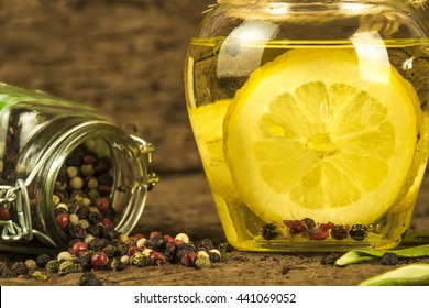 Olive oil flavored with lemon and  peppercorns in  glass bottle on old wooden background - Powered by Shutterstock