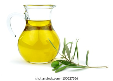 Olive oil in glass carafe and green olive branch isolated on white background.
