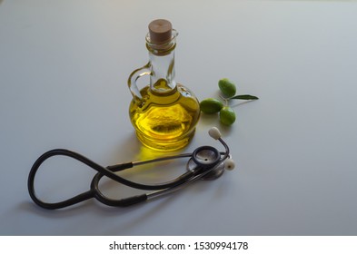 Olive oil, olives and stethoscope on white background.Heart health and healthy eating concept.