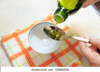 Olive oil on a teaspoon for background.