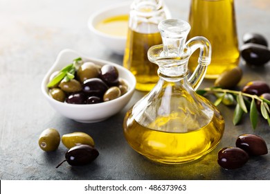 Olive oil in vintage bottles with black and green olives and leaves copyspace on rustic background - Powered by Shutterstock