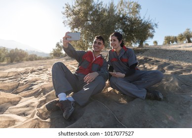  OLive oil workers having a break after work on a mantle with phones - Powered by Shutterstock