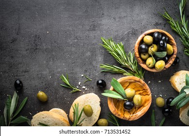 Olives, Olive Oil Rosemary And Bread On Black Slate Background. Top View  Copy Space.