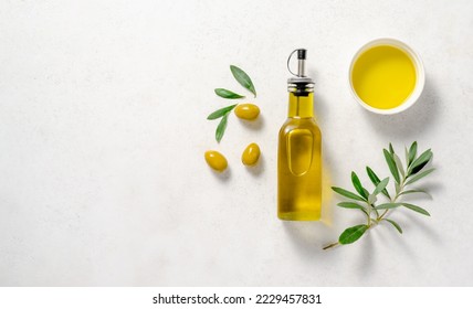 Olives and olive oil in white bowl with bottle of olive oil on white background. Mockup for package. Copy space. - Powered by Shutterstock