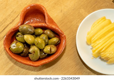 Olives in a traditional Alentejo container made of clay and traditional Alentejo sheep's milk cheese. - Shutterstock ID 2263343049