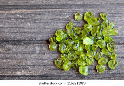 Olivine gemstone also called Peridot on old wooden background. Selective focus.
