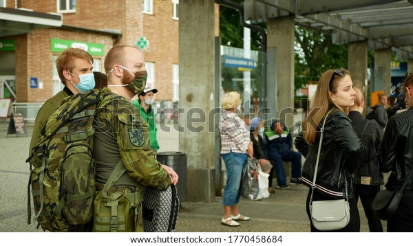 OLOMOUC, CZECH REPUBLIC, JUNE 22, 2020:\
Coronavirus mask face people crowd tram streetcar stop tram army\
soldier passengers board, public transport prevention risk covid-19\
safety outbreak