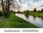 Olse river with trees and meadows around near Most Sokolovskych hrdinu bridge in Karvina city in Czech republic during beautiful autumn day