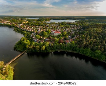 Olsztyn Lake Dlugie, bird's eye view. Wooded shores, the sky reflecting in the water table and a bridge over the lake - Warmia and Masuria, Poland - Shutterstock ID 2042488592