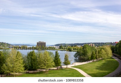 Olympia, Washington / USA - May 5, 2018:  People stroll and run through the Capitol Lake Park on a clear and beautiful spring day with the Olympic Mountain range visible in the distance.