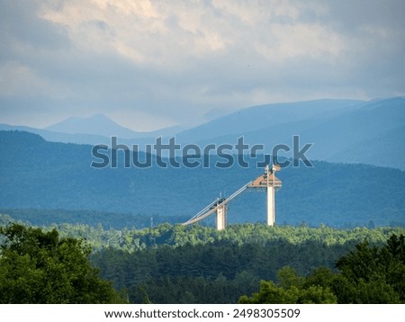 The Olympic Jumping Complex in Lake Placid, Upstate New York, glows under the late evening sun, framed by distant mountains and serene landscapes.