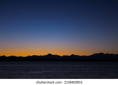 The Olympic mountains silhouette and the sunset view from Golden Gardens park, Seattle, Washington