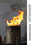 Olympic torch lit with high heat and showing smoke from burning