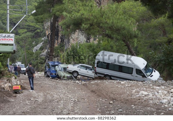 OLYMPOS, TURKEY - OCTOBER 14: Crashed cars and\
people in the woods after flood disaster on October 14, 2009 in\
Olympos, Turkey, Asia. The floods destroy  roads and houses and\
swept away about 50\
cars.