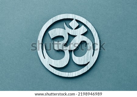 Om or Aum symbol of Hinduism and Buddhism on blue background