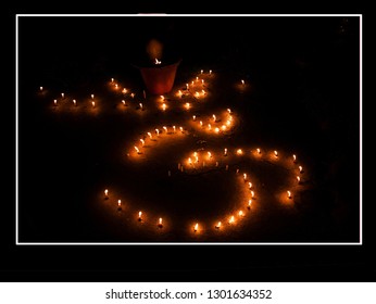 Om sign laid out from burning candles during a Hindu holiday. Photo taken in south india state
  Kerala. Diaphragm f / 3.5, shutter speed 1/300, ISO 3200, focal length 18mm.