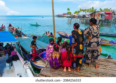 Omadal Semporna, Malaysia-Nov 19, 2021: Bajau Laut Women In Colorful Clothes On The Bamboo Jetty Where Boats Drop Off Passengers. Boats Are The Main Transportation In The Islands Around Semporna.