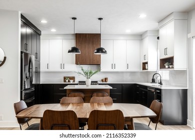 OMAHA  NE USA - 02-01-2022 - Midcentury modern kitchen and dining room interior design with black cabinets, white cabinets, white quartz and walnut accents