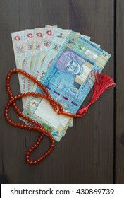 Omani Riyal Currency Notes And Islamic Prayer Beads. Sharia'h Or Islamic Banking.