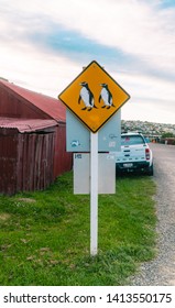 Omaru, New Zealand - Jan 2019: Cute, Funny Yellow Penguin Crossing Road Sign. Road And Sky Background. Shot In South Island, NZ