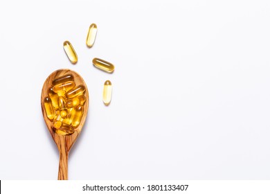 Omega 3 cod liver oil capsules in the wooden spoon on white background with copy space for your design. immunity support capsules. Health care concept. - Shutterstock ID 1801133407
