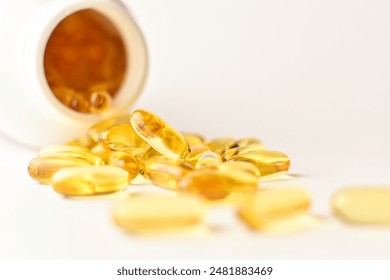 Omega 3 fish oil capsules spilling out of a bottle on a white background  - Powered by Shutterstock