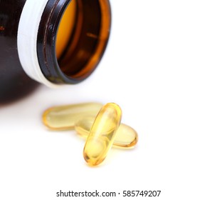 Omega 3 fish oil capsules on white.Pile of yellow softgel pills closeup on white background.Healthy nutrition and lifestyle concept. Nutraceuticals with omega3 polyunsaturated fatty acids.

