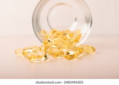 Omega 3 fish oil pours out of the glass on pink background. Vitamins, cod liver oil closeup. Front view. Concept of healthcare, supplements, vitamin D. Copy space, banner. High quality photo - Powered by Shutterstock