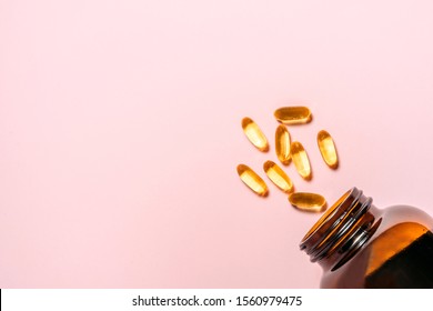 Omega 3 Gel Capsules With Bottle. Fish Oil Pills. Healthy Omega-3 In Bottle. Pink And Mint Color Background.