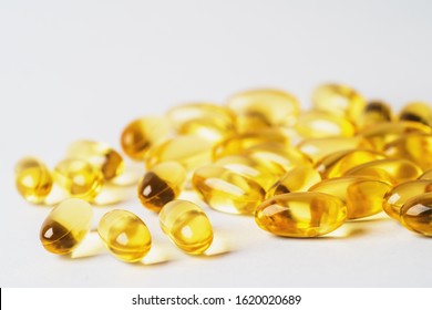 Omega 3 Yellow Pills On White Background. EPA And DHA Are Two Types Of Omega-3 Fats Essential Fatty Acids For Healthy Living.