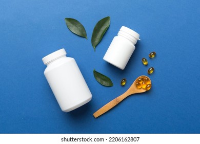Omega-3 capsules lie in white bottle on a table with green leaves background. Fish oil tablets. Biologically active additives. omega 6, omega 9, vitamin A, E, D, vitamin D3 top view with copy space. - Shutterstock ID 2206162807