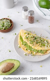 Omelet with avocado and microgreens on a gray background. Breakfast service. Beautiful breakfast with avocado.