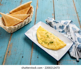 Omelet with bread served in a dish side view of breakfast isolared on wooden table
