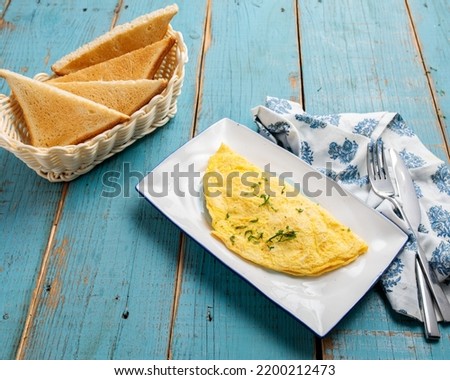 Omelet with bread served in a dish side view of breakfast isolared on wooden table