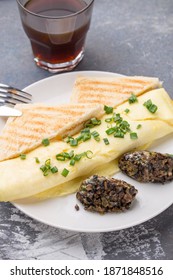 Omelette With Fried Champignon Mushrooms, Cheese And Toasted Bread And Cup Of Coffee On Gray Table Side View