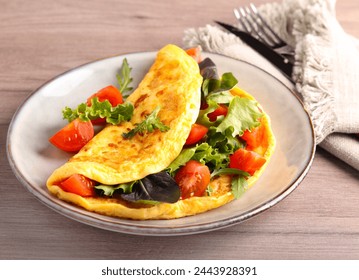 Omelette with salad and tomatoes on plate