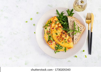 Omelette With Tomatoes, Ham, Cheese And Green Herbs On Plate.  Frittata - Italian Omelet. Top View, Overhead, Copy Space