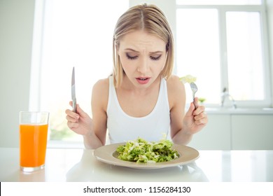 Omg it's not tasty! Where is meat? Weight loss concept. Close up photo portrait of sad upset uncertain unsatisfied crying blonde-haired lady holding cutlery in hands looking at bowl