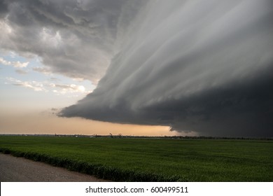 An ominous, sculpted supercell thunderstorm advances over wheat fields in western Oklahoma.