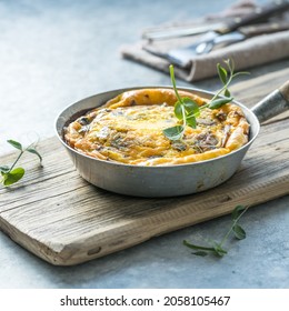 Omlet with mushrooms in a pan on a concrete background. Fritata is an Italian breakfast dish.