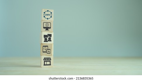Omnichannel marketing concept. Digital online marketing commerce sale. Customer engagement integrated online and offline channels. Stacking wooden cubes with omni text standing on other omni icons.