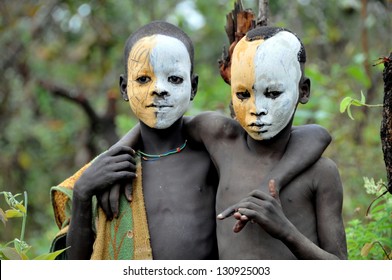OMO VALLEY, ETHIOPIA - FEB 5: unidentified Surma posing by the river and painting themselves,. Surma in the Omo valley,could disappear because of Gibe III hydroelectric dam on Feb 5, 2013 in Omo Valley, Ethiopia.