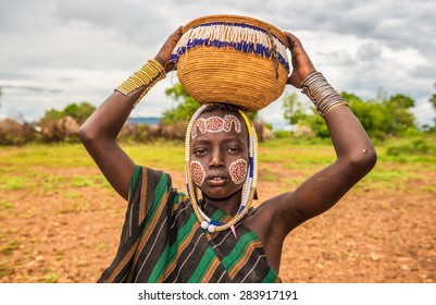 OMO VALLEY, ETHIOPIA - MAY 7, 2015 : Young boy from the African tribe Mursi with traditional jewelry in Mago National Park, Ethiopia.