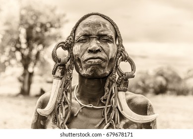 OMO VALLEY, ETHIOPIA - MAY 7, 2015 : Warrior from the african tribe Mursi with traditional horns in Mago National Park, Ethiopia.  Vintage black and white processed.