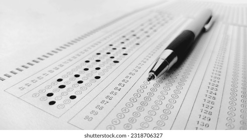 omr,exam, entrance exam, SAT, national testing agency,Pen on papers and forms .Man is filling OMR sheet handing with pen. Optical Mark Recognition, defocused image and contains noise for texture.