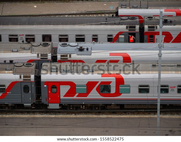 Omsk,\
Russia - 08.14.2019: Many passenger trains on the railway of\
Russia. There are many passenger train cars in parallel standing\
near the Omsk station. Sump for passenger\
trains