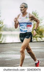 Omsk, Russia -  September 20, 2015: Closeup Old Man Runner Running Along River During Siberian International Marathon