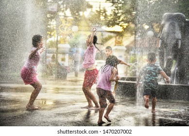 On August 4, 2019 at 10.00 o'clock in the morning, there are 5 children.  Is enjoying playing water from the fountain  In the park to relax the heat from the air  In Chiang Mai, Thailand