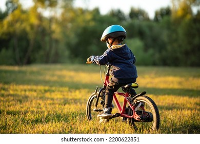 On an autumn afternoon, a little boy happily rode his bike outside wearing a safety helmet - Powered by Shutterstock