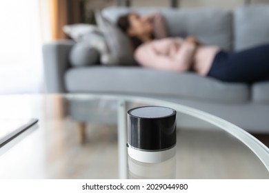 On Background Serene Woman Lying On Sofa In Living Room Enjoy Good Quality Sound, Close Up Focus On Table, Smart Portable Wireless Loudspeaker Play Music. Digital Assistant, Modern Device Ad Concept